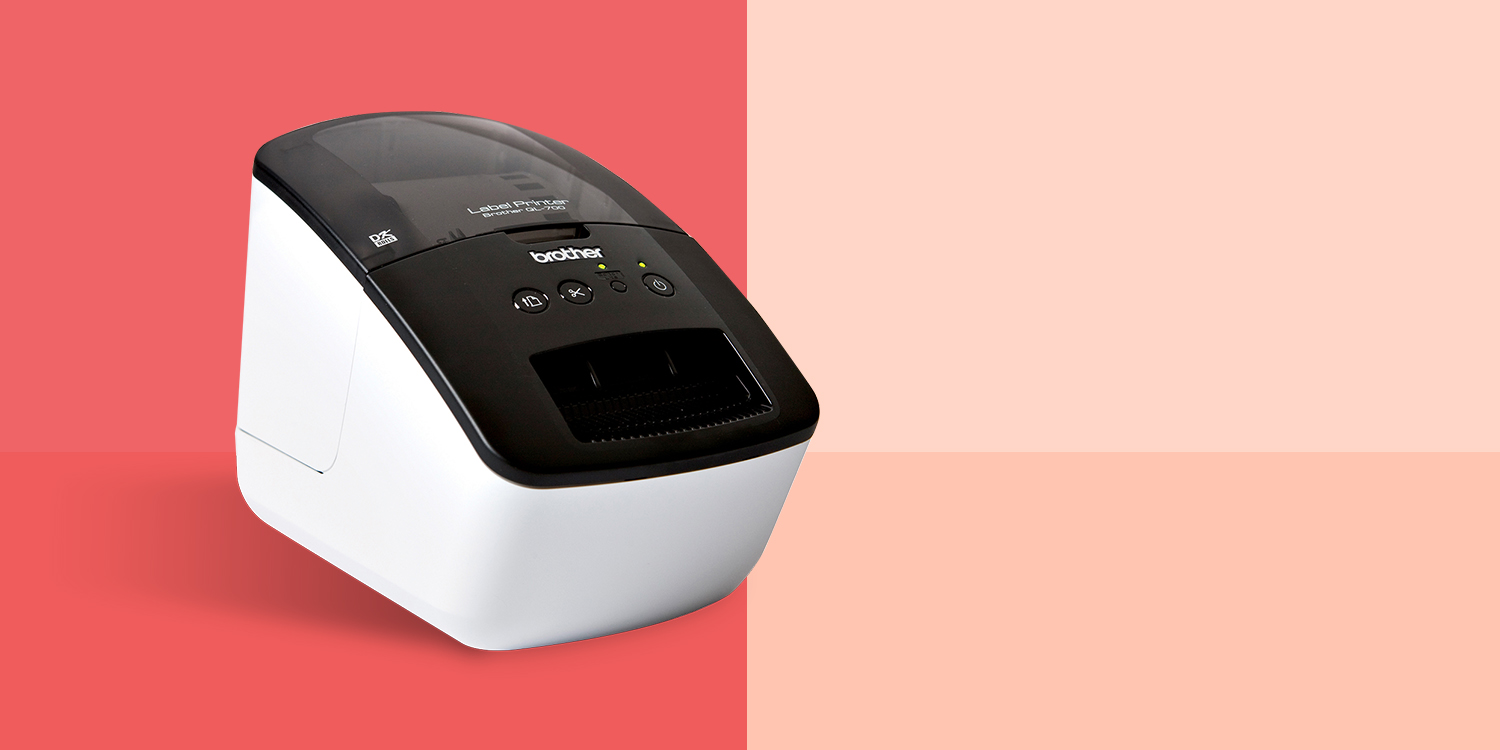 Brother label printer with a black top and white body on a red and peach background.