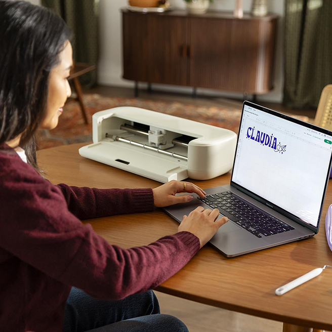 person working on a laptop using Design Space software.