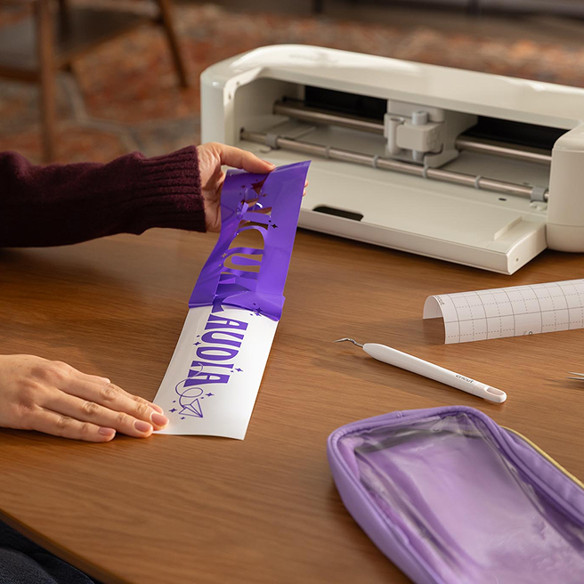 person pealing back vinyl to reveal their design.